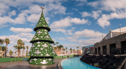 Christmas tree decorations and market outdoors, on the beach in Las Palmas de Gran Canaria, in winter holiday, Spain - obrazy, fototapety, plakaty