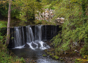 Scenic autumn landscape with Boulzane river and waterfall among trees and foliage in the lower...