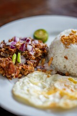 Closeup shot of a rice dish served with roasted nuts and fried egg, also known as Nasi lemak