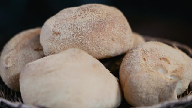 Closeup shot of Pandesal served in a woven basket spinning