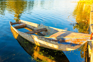 Wooden old fishing boat landscape on river at sunset