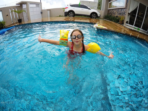 menina feliz na piscina 