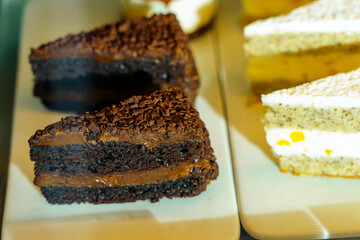 Pieces of chocolate cake are on the counter for sale