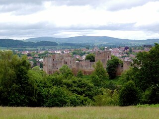 Fototapeta na wymiar Ludlow castle with mountains in the background under a cloudy sky
