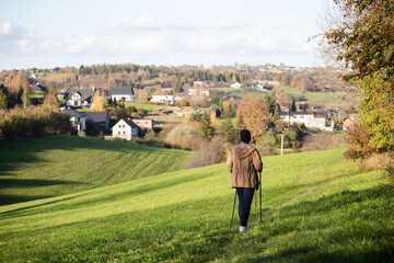 Lady nordic walking lifeystle hikes on meadow in a countryside