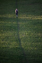 Lady walks downhill nordic walking on a meadow