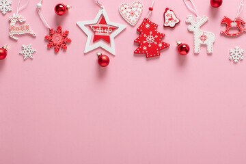Christmas composition with red and white Christmas tree toys at the top on a light pink background.