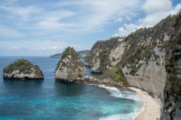 High-angle of Diamond beach with cliffs covered with grass, sunlit, cloudy sky background