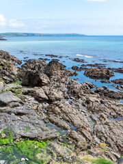 Picturesque seascape. Rocky shore on a sunny day. Clear blue sea and clear blue sky. Beautiful coast of the Atlantic Ocean.