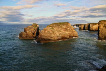 Beautiful shot of huge cliffs during the high tide, beach of the Cathedrals in Ribadeo Lugo, Galicia