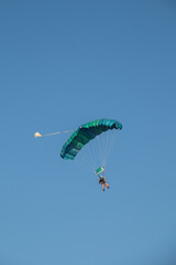 skydiver descending over clear midday sky