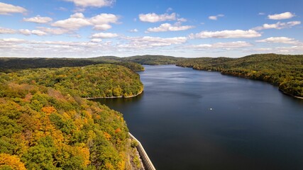 Drone shot of the water of New Croton Reservoir on a sunny day in autumn with a blue cloudy sky