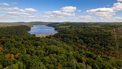 Drone shot of the New Croton Reservoir and dam with greenery landscape on a sunny day in autumn © Audley C Bullock/Wirestock Creators