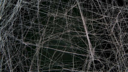 Halloween, decor and horror concept, decoration of artificial white spiderweb over black background. White wavy threads or fiber are hung on a black background. Sinister, mysterious decor for holiday.