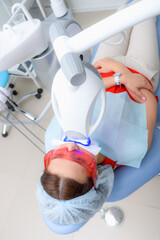 the patient undergoes a procedure for teeth whitening with an ultraviolet lamp