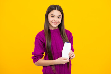 Fototapeta premium Teen child girl with shampoo bottle or shower gel isolated on yellow background. Kids hair cosmetic product.