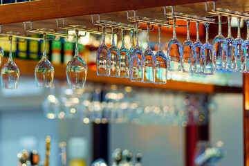 Different wine glasses hang over the bar counter