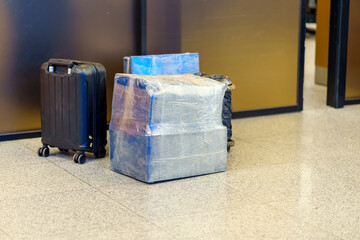 Fototapeta na wymiar Boxes wrapped in polyethylene for checking in the luggage of the aircraft are near the door