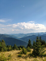 Summer and autumn hiking in the Carpathian mountains, stunning views from the tops, blue cloudy sky, fog