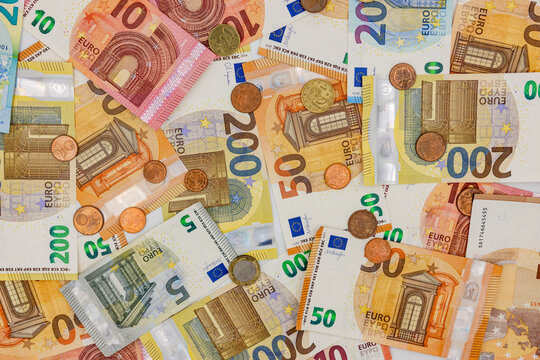 Lots of money with euro banknotes, coins and colorful banknotes as a background in top view representing wealth and luxury