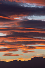 Spectacular lenticular clouds at dawn over the silhouette of the Sierra Nevada peaks (Granada, Spain) in autumn