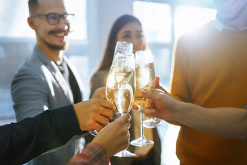 Toasting to success concept.Group of young business people toasting each other and smiling while standing in the office. Celebration and festive concept.
