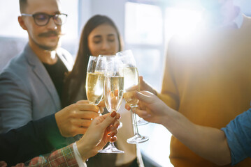 Toasting to success concept.Group of young business people toasting each other and smiling while standing in the office. Celebration and festive concept.