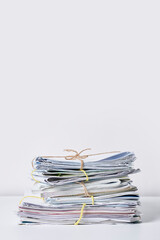 a stack of newspapers tied with twine rope on a white background stock photo - premium, high resolution, code no 1