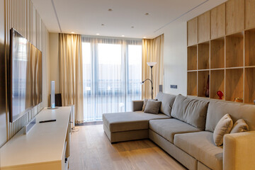cozy bright living room with a large window, sofa and TV