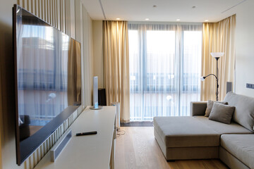 cozy bright living room with a large window, sofa and TV