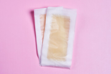 two pieces of ice on a pink background, one is frozen and the other is unpacked in plastic bags