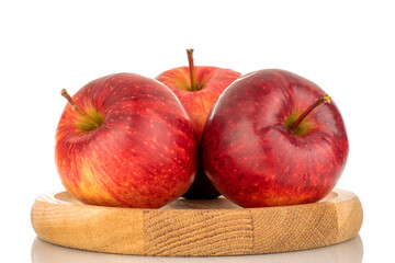 Three red ripe apples on a wooden plate, macro, isolated on white background.