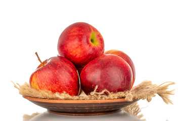 Several red ripe apples on a wooden plate, macro, isolated on white background.