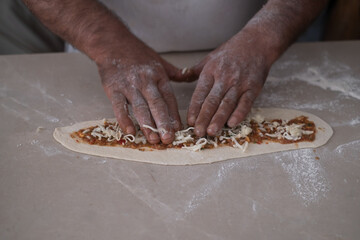 chef hand cookind pide on kitchen table