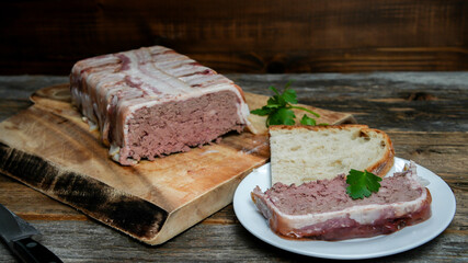 Home made pate wrapped in bacon  from pork and liver on rustic table