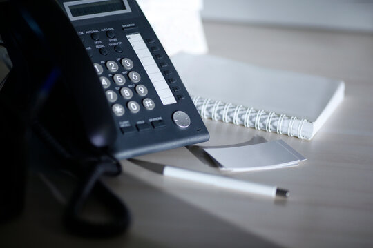 Graphite telephone on the office desk with white pen, clean name cards and notebook mockup 