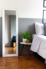 Stylish bedroom with mirror. Modern classic design. Comfortable home interior.