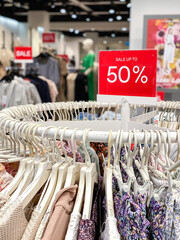 Circle rack with hangers and sale sign.