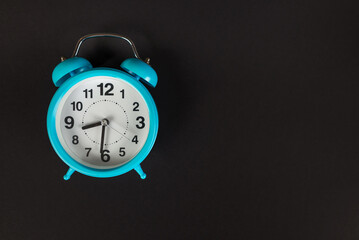 Blue alarm clock isolated on black background