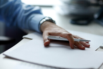 Businessman with white pen in his hand signing a paper document mockup