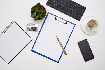 an office desk with a laptop, notepad, pen and coffee on it next to a cup of coffee