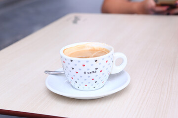 cup of coffee with cream and coffee beans closeup photo