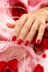 Red manicure with roses on short square nails.