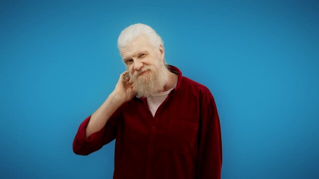 Stylish man in his 60s winking and flirting on camera, handsome charming grandpa