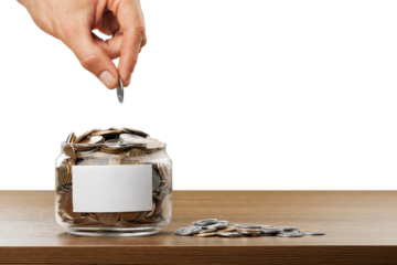 Hand putting coins in a glass jar with a blank label