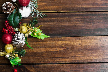 Fototapeta na wymiar Christmas Holiday evergreen branches and red berries over wood background with copy space