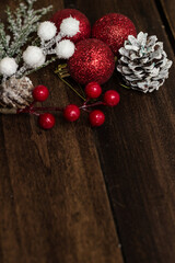Christmas Holiday evergreen branches and red berries  over wood background with copy space