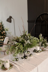 Festive New Year's table with candles and handmade Christmas decorations and live floristry