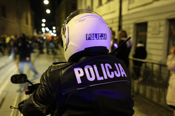 Policjant wydziału ruchu drogowego z motocyklem podczas kontroli miasta wieczorem.  Światła policyjne.