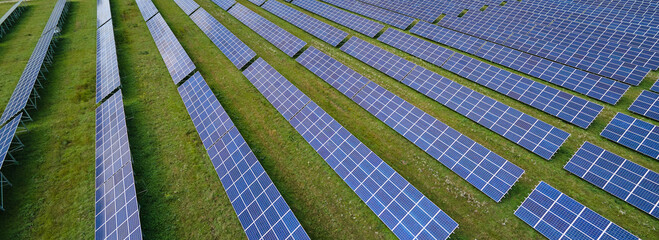 Aerial view of large sustainable electrical power plant with rows of solar photovoltaic panels for...